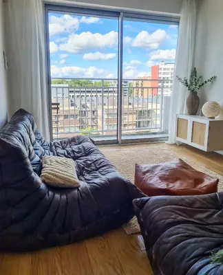 a living room with a couch and a large window at Stijlvol App in Genk Centrum in Genk