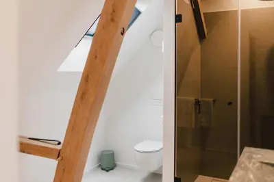 a bathroom with a toilet and a glass shower at Entre Nous in Herk-de-Stad