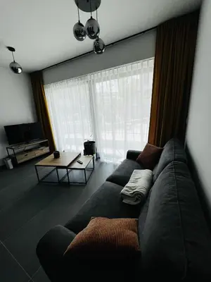 a living room with a couch and a table at TB Trianon - Appartement Chic & Cosy in Liège