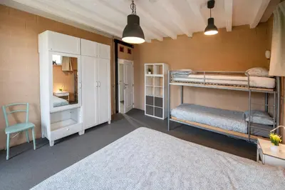 a room with two bunk beds and a chair at Smishoeve 