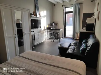 a room with a bed and a couch and a kitchen at 
