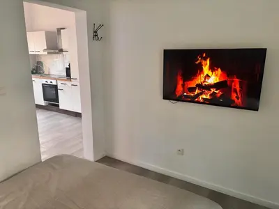 a living room with a fireplace on the wall at FourSuites Liège in Liège