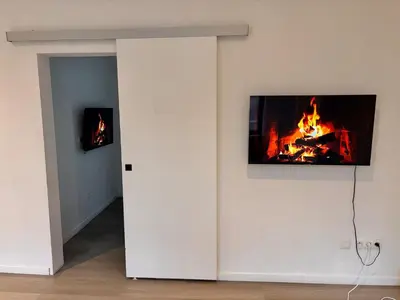 a living room with a fire on the wall at FourSuites Liège in Liège