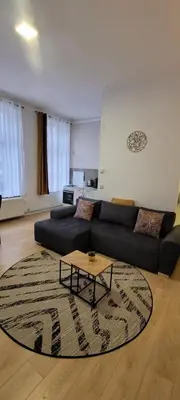 a living room with a black couch and a coffee table at Au coeur du théâtre in Verviers