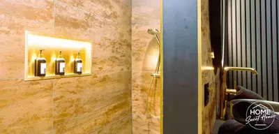 a bathroom with a shower with wine bottles on the wall at Home Sweet House in Hermée
