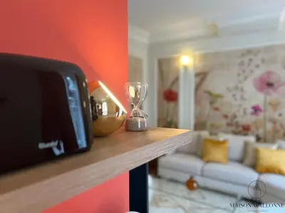a living room with a table with a clock on a counter at L'haussmanien romantique - HEC, Jardin botanique in Liège