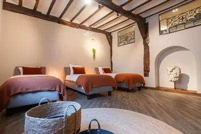 two beds in a room with wooden floors and beams at De Droomhoeve in Bilzen