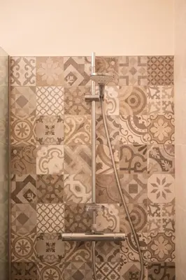 a shower in a bathroom with a tile wall at De Droomhoeve in Bilzen