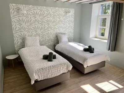 a room with two beds and a wall at Gite 13 personnes in Battice