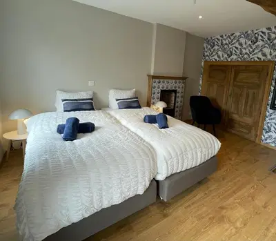 a bedroom with a large white bed with blue pillows at Gite 13 personnes in Battice