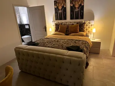 a bedroom with a large bed with a large headboard at Villa kleinwellness in Lanaken