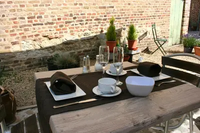 a wooden table with glasses and plates and wine glasses at B&B Horpala in Heers