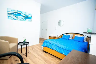 a bedroom with a bed and a chair and a table at Chambre R1 avec salle de bain privée in Liège