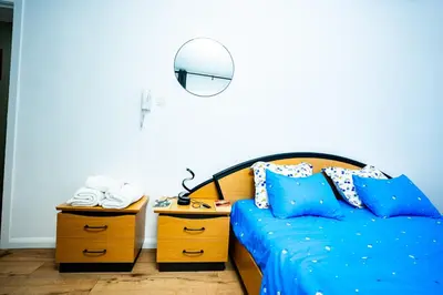 a bedroom with a bed with blue sheets and a lamp at Chambre R1 avec salle de bain privée in Liège