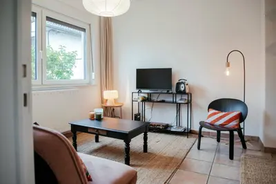 a living room with a tv and a chair and a table at La Courte Échelle in Verviers