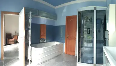 a bathroom with blue walls and a bath tub at Just for sleep in Liège