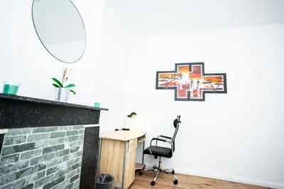 a room with a desk and a chair and a mirror at Chambre R1 avec salle de bain partagée près de l'hôpital de la Citadelle à Liège in Liège