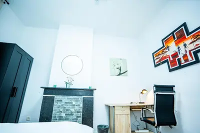 a bedroom with a fireplace and a desk and a chair at Chambre R1 avec salle de bain partagée près de l'hôpital de la Citadelle à Liège in Liège