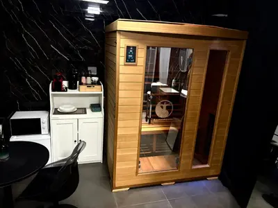 a small wooden cabinet in a kitchen with a table at La Suite Gold Wellness Jacuzzi & Sauna in Seraing