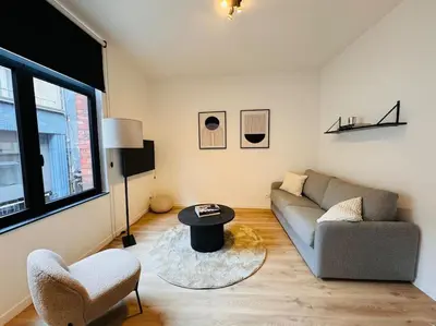 a living room with a couch and a table at Urbanchic Opéra 2B in Liège