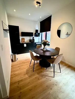 a dining room with a table and chairs in a room at Urbanchic Opéra 2B in Liège
