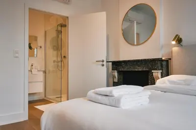 a bedroom with a bed with a mirror and a fireplace at Urbanchic atmosphère 2D in Liège