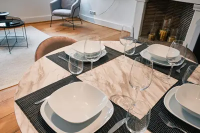 a table with plates and wine glasses on it at Urbanchic atmosphère 2D in Liège