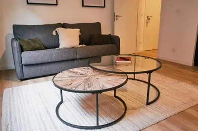 a living room with two tables and a couch at Urbanchic Appartement cosy 1B in Liège
