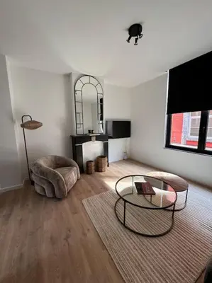 a living room with a table and a cat on the ceiling at Urbanchic Appartement cosy 1B in Liège