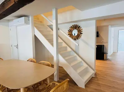 a dining room with a table and a staircase at Urbanchic Appartement Evasion 3D in Liège