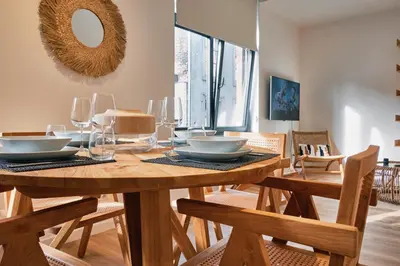 a dining room with a wooden table and chairs at Urbanchic Appartement Chill 3B in Liège