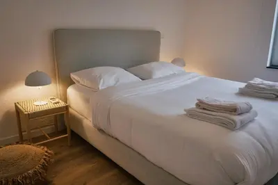 a bedroom with a white bed with towels on it at Urbanchic Appartement Chill 3B in Liège