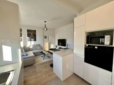 a kitchen and living room with a couch and a table at Modern Business Flat - Courts et moyens séjours in Liège