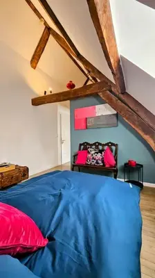 a bedroom with a blue bed with red pillows at Das GANZE Chateau Thor - bis zu 22 Personen in Lontzen