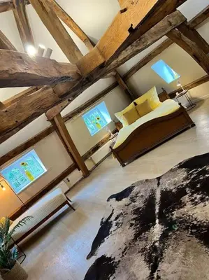 a bedroom with a bed in a room with wooden ceilings at Das GANZE Chateau Thor - bis zu 22 Personen in Lontzen