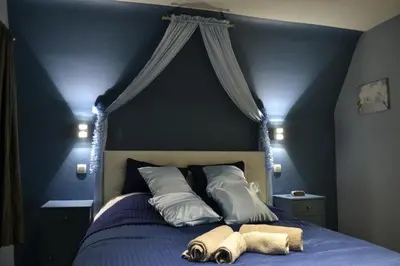 a blue bedroom with a bed with two towels on it at B&B Noord-Zuid in Zonhoven