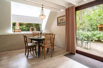 a dining room with a table and chairs and a window at Boshuisje Rekem - Fleur in Lanaken