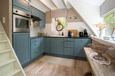 a kitchen with blue cabinets and a sink at Boshuisje Rekem - Fleur in Lanaken