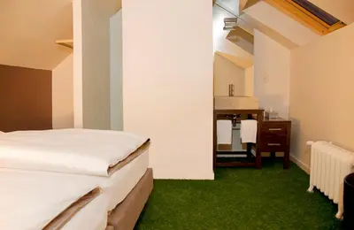 a bedroom with a bed and a bathroom with a sink at A la Maison in Heks