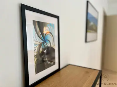 two framed pictures on a wall next to a table at Le paisible écrin - Hypercentre avec Parking in Liège