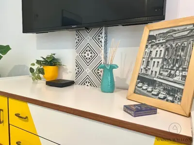 a desk with a tv and a vase on it at Le paisible écrin - Hypercentre avec Parking in Liège
