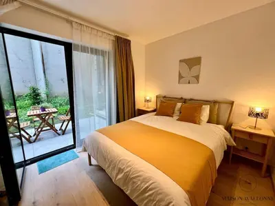a bedroom with a bed and a sliding glass door at Le paisible écrin - Hypercentre avec Parking in Liège