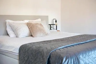 a bedroom with a large bed with white sheets and pillows at Vakantiewoning Huis 8 in Tongeren
