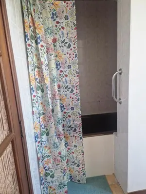 a shower curtain with a floral pattern in a bathroom at Appartement à la campagne in Juprelle