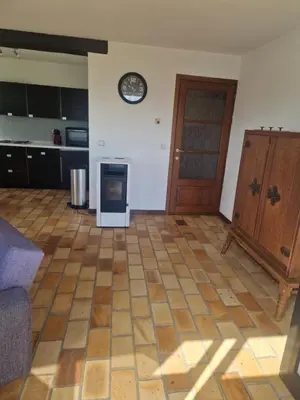 a kitchen with a stove and a clock on the wall at Appartement à la campagne in Juprelle