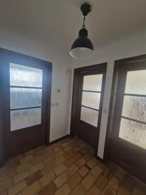 an empty room with two doors and a pendant light at Appartement à la campagne in Juprelle