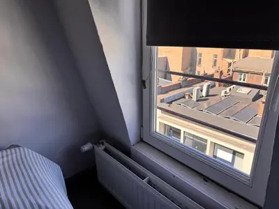 a window in a room with a view of a building at Charming Apartment in Liège City Centre with Parking Included in Liège