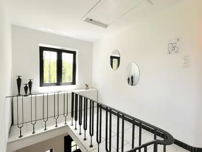 a staircase in a white room with a window at Hestia in Oudsbergen
