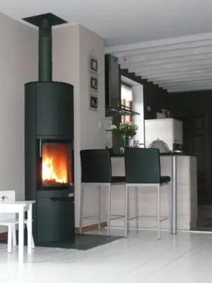a living room with a fireplace and a table and chairs at Gite des Comagnes in Limbourg