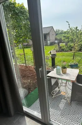 a sliding glass door leading to a patio with a table at B&B Bombon in Herk-de-Stad